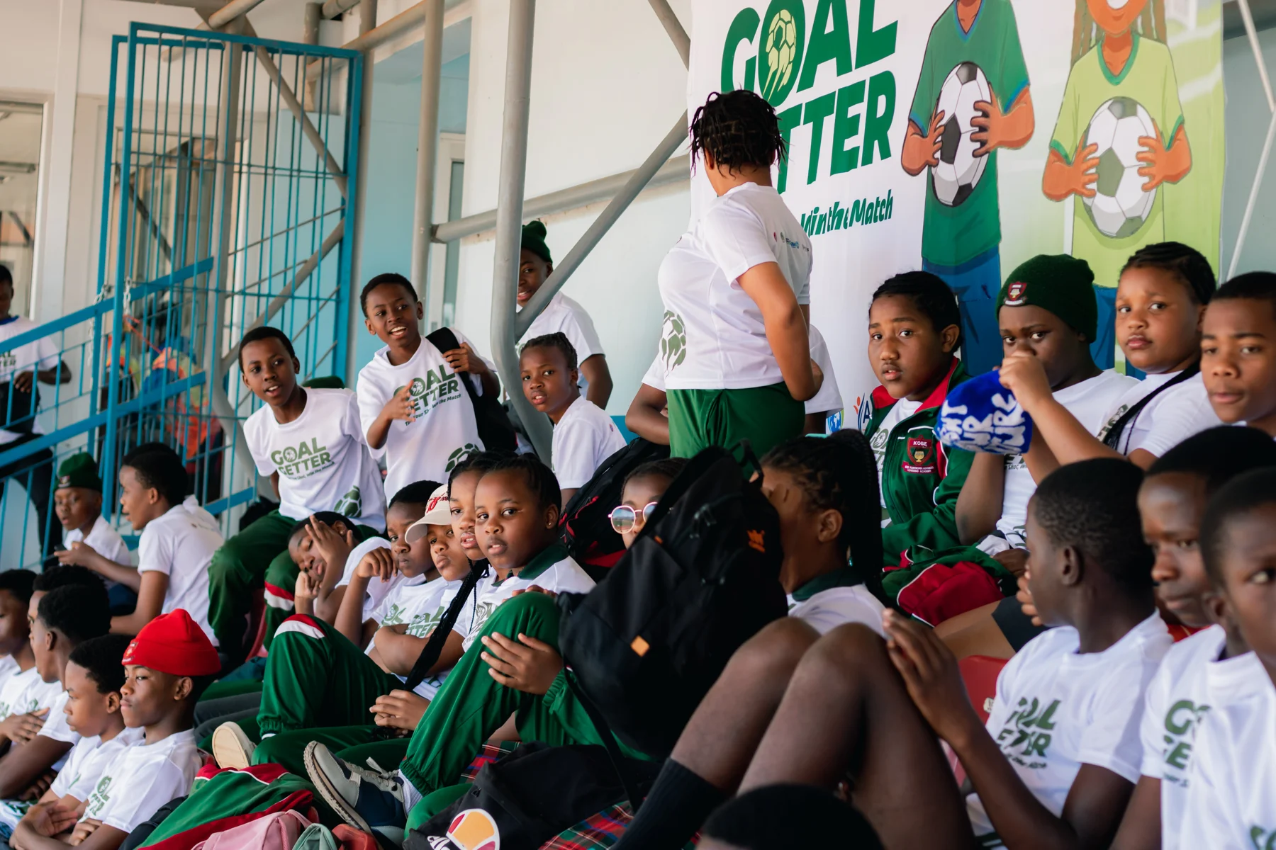 Participants gathering in the red stadium seats for the Goal Getters workshop